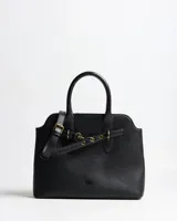 Cartera tipo tote bag color negro de símil cuero con textura granulada, asas de mano y correa bandolera ajustable. Cuenta con herrajes dorados envejecidos y tira decorativa frontal con hebilla.