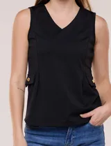Chaleco blanco sin mangas de estilo smart-casual, con escote en V y costuras verticales de entalle. Cuenta con bolsillos o solapas simuladas a los lados de la cintura decorados con un botón metálico dorado y un largo a la cadera.