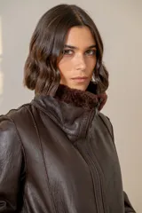 Campera reversible confeccionada en cuero ovino, con interior de piel sintética blanca. Presenta cierre frontal, cuello alto y bolsillos laterales amplios.