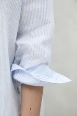 Camisa celeste con rayas verticales blancas, de lino.