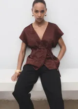 Chaleco de tejido satinado con efecto arrugado, diseño cruzado con cuello pico y cierre de lazo en la cintura.