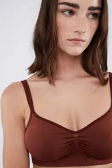 Soutien tipo bralette de microfibra sin costuras, con diseño de doble bretel regulable y detalle fruncido en el centro del escote. Cuenta con cierre de broche doble en la espalda con tres niveles de ajuste.