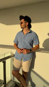 Camisa celeste de manga corta con cuello clásico y cierre frontal con botones.