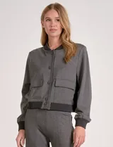 Chaqueta tipo bomber marca Elan, confeccionada en una mezcla de rayón y elastano. Presenta un diseño en color gris con cuello a la base, cierre frontal de botones y bolsillos delanteros con solapa. Cuenta con terminaciones de rib elástico en un tono gris oscuro en el cuello, los puños y la cintura.