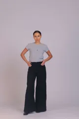 Pantalón de corte wide leg confeccionado en pana acanalada color marrón chocolate. Presenta tiro alto, cierre frontal con botón y bolsillos laterales.