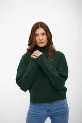 Sweater de punto con cuello alto, manga larga y diseño holgado.