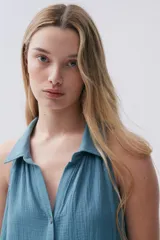 Vestido largo sin mangas color celeste, de bambula, con cuello camisero, abotonado al frente y falda con volados.
