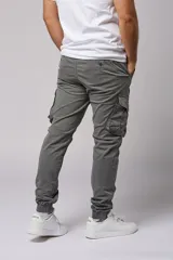 Pantalón cargo color beige de gabardina, con corte ajustado, bolsillos laterales con fuelle y puños elásticos en los tobillos.