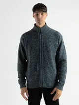 Campera de punto con cierre frontal, cuello alto y forro interno. Presenta un diseño de tejido jaspeado con puños y ruedo acanalados, e incluye un pequeño aplique de marca en la parte inferior.
