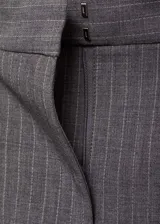 Falda larga de corte recto con diseño a rayas verticales finas. Presenta tiro medio, trabillas para cinturón, bolsillos laterales y una abertura frontal en el bajo. Incluye cierre oculto de botón, gancho y cremallera.
