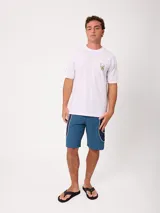 Remera Rusty de corte holgado, color amarillo, con estampa en la espalda de un personaje surfeando sobre un pez y textos descriptivos.