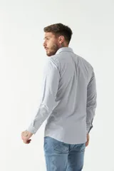 Camisa de manga larga para hombre, color azul claro con microestampado de cuadros. Presenta un corte slim y cuello abotonado.