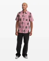 Camisa de manga corta Volcom modelo Abg Markerstone, color rosado con estampado tropical, cuello camisero, cierre frontal de botones y bolsillo en el pecho.