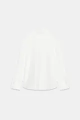 Camisa amplia blanca de cuello alto y manga larga, con cierre frontal de botones.
