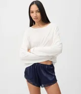Short de pijama azul marino de satén con acabado brillante y caída fluida, cintura elastizada con moño decorativo y detalles de encaje en los bajos.