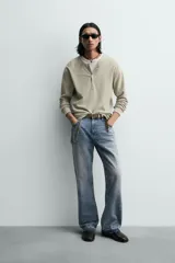 Camiseta de manga larga para hombre con corte relajado, confeccionada en tejido con estructura waffle. Presenta un cuello redondo tipo panadero con cierre frontal de botones a presión.