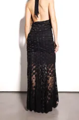 Falda larga de encaje negro con diseño de rombos y base con frunces.