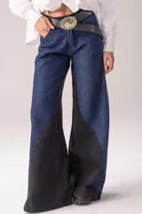 Jean wide leg de tiro alto en combinación de denim azul y negro, con diseño bicolor de paneles laterales en contraste y corte acampanado.