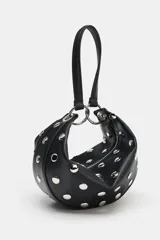 Bolso de mano tipo saca con diseño redondeado, confeccionado en material sintético color marrón oscuro. Presenta múltiples tachas metálicas doradas distribuidas por toda la superficie y un asa superior sujeta por anillas metálicas doradas. Cuenta con cierre superior mediante cremallera metálica.