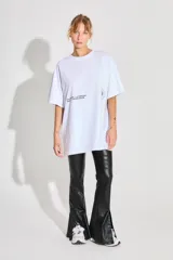 Remerón blanco de jersey 24/1 peinado, corte oversized, mangas cortas y ruedo ancho. Estampa serigrafiada en frente y espalda a contratono.