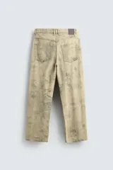 Pantalón de corte baggy fit confeccionado en tejido de algodón con textura y efecto lavado. Presenta diseño de cinco bolsillos, cierre frontal con cremallera y botón.