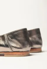 Chatas planas de cuero vacuno, color peltre metalizado, con punta cuadrada y escote pronunciado en el empeine.