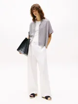 Camisa de manga corta con cuello clásico y cierre frontal con botones. Diseño a rayas verticales en blanco y negro.