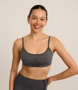 Top deportivo sin copa de diseño seamless, color gris melange, con escote redondo, breteles finos ajustables y detalles texturizados en la parte frontal.