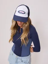 Gorra azul marino de lona con visera curva y malla trasera. Presenta logo bordado en el frente.