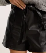 Short corto color marrón oscuro, confeccionado en poliuretano (PU) con textura que imita el cuero. Presenta cintura elástica en la parte trasera, lazo delantero para ajustar y recortes decorativos.