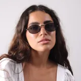 Lentes de sol con armazón metálico fino y cristales oscuros de forma ovalada.