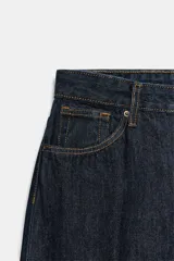 Jeans de tiro alto en denim azul oscuro, de corte tapered y diseño bombacho con pinzas frontales. Cuenta con bolsillos clásicos y costuras en tono tabaco.
