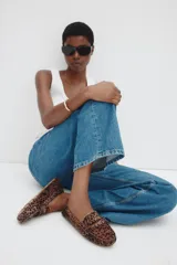 Mocasines tipo penny con pelo sintético estampado de leopardo. Presentan costura tradicional en el empeine y forro interior de sarga de algodón.