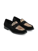 Mocasín de gamuza negra con detalle de pelo sintético con estampado animal print tipo cebra en el empeine.