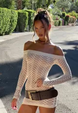 Vestido corto blanco de tejido de red, con escote off-shoulder y mangas largas.