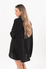 Vestido camisero corto negro, con escote en V, cuello clásico, mangas tres cuartos regulables y detalle de pez bordado a mano en la espalda.