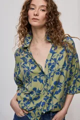 Camisa de calce amplio confeccionada en viscosa fluida con estampado animal print tipo cebra en blanco y negro. Presenta cuello camisero, escote en V y mangas largas con puños elastizados, además de frunces en el canesú que aportan volumen.