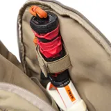 Mochila deportiva color verde oliva, confeccionada en material textil con acabado arrugado. Cuenta con compartimento principal amplio, bolsillo frontal con cierre, compartimento inferior independiente para calzado y tirantes ergonómicos ajustables. Incluye logo circular de la marca en el frente.