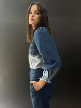 Campera de jean azul con lavado artesanal, entallada y corta hasta la cintura alta. Presenta textura central en el delantero.