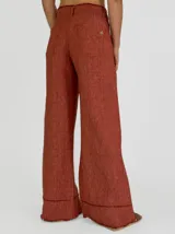 Pantalón palazzo color ladrillo, de tiro alto y corte amplio. Confeccionado en lino.