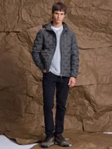 Campera de nylon termosellada con capucha, diseño acolchado y cierre frontal completo.
