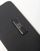 Billetera XL Extra Large modelo Celeste Fichero, color negro con textura geométrica, cierre perimetral y aplicación frontal con el logo de la marca en herraje dorado.