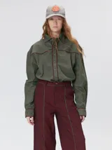 Pantalón sastrero de tiro medio y pierna ancha, con diseño a rayas verticales finas y detalle de vivos negros en la pretina y a lo largo del frente.