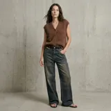 Jean de corte wide leg con efecto desgastado y lavado vintage. Presenta cintura media, bolsillos laterales y traseros, y un ruedo con terminación desflecada.