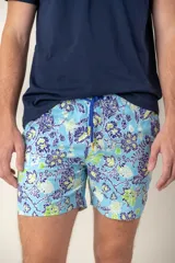 Short de baño para hombre, color celeste, con estampado floral en tonos azul oscuro y verde lima. Posee cordón ajustable en la cintura de color azul con detalles amarillos.