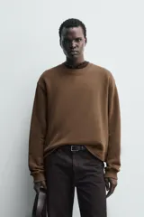 Sudadera de corte boxy fit, color marrón, con cuello redondo y manga larga. Presenta acabados en rib en puños y ruedo.