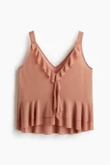 Musculosa rosada de punto liviano con breteles anchos, escote en V con volados en el borde y dobladillo con doble capa de volados.
