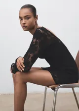 Vestido corto de crochet color negro, con cuello redondo, manga larga acampanada, espalda abierta con cierre de lazo y forro interior.