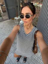 Vestido corto tejido a rayas horizontales en blanco y negro, sin mangas y con cuello redondo.