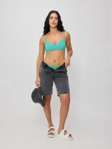 Bermuda de jean azul oscuro, corte recto y largo hasta la rodilla. Confeccionada en denim 100% algodón, con bolsillos delanteros y traseros.